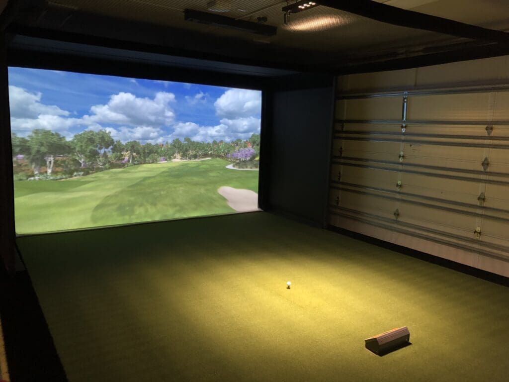A garage with a golf simulator screen.